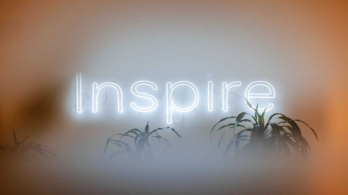Illuminated Inspire neon sign on a wall in the BKN301 office