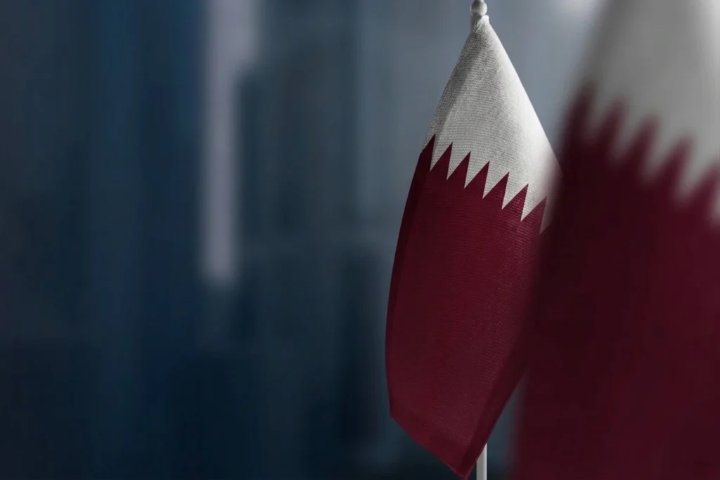 Qatar national flag in close-up against a dark blue background, illustrating asset tokenization and the growth of digital and real-world assets in Qatar