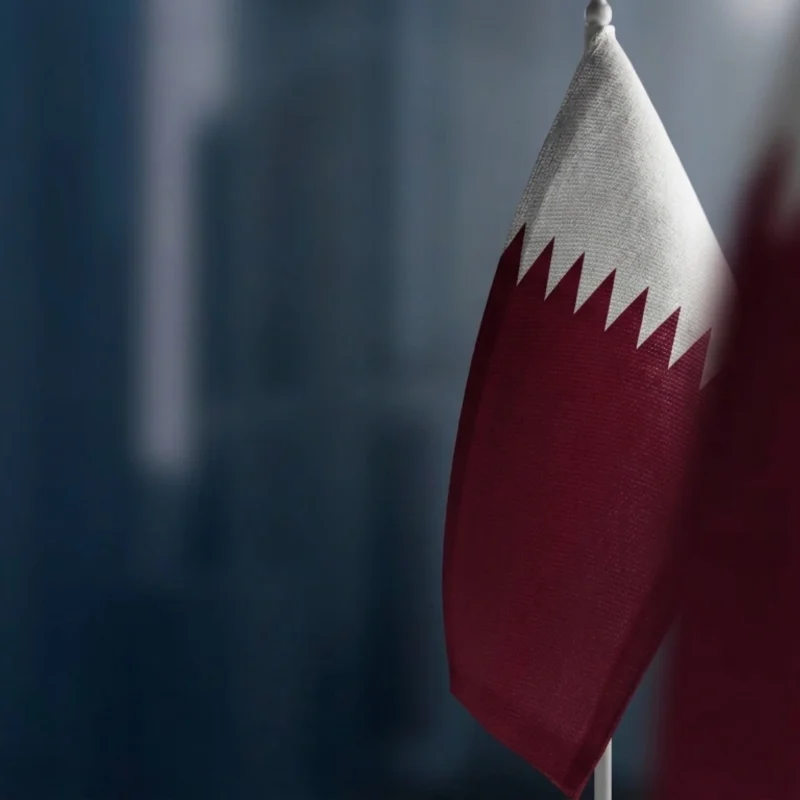 Qatar national flag in close-up against a dark blue background, illustrating asset tokenization and the growth of digital and real-world assets in Qatar
